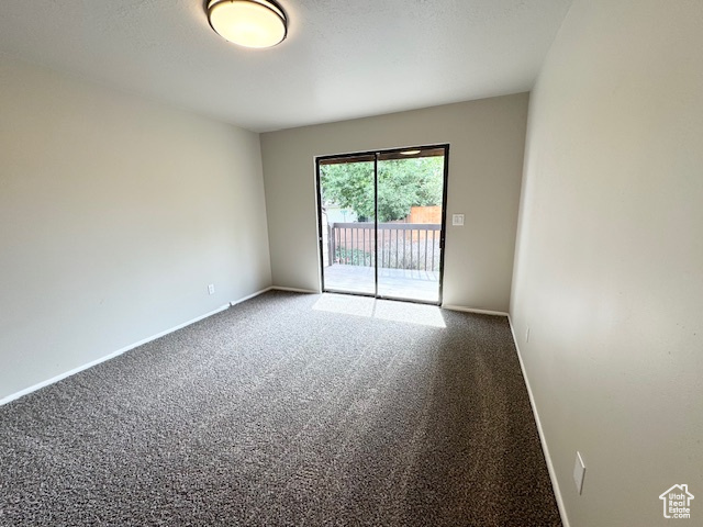 Spare room featuring carpet flooring and baseboards