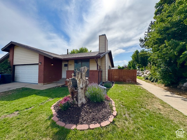 Ranch-style house with an attached garage, brick siding, a chimney, and driveway