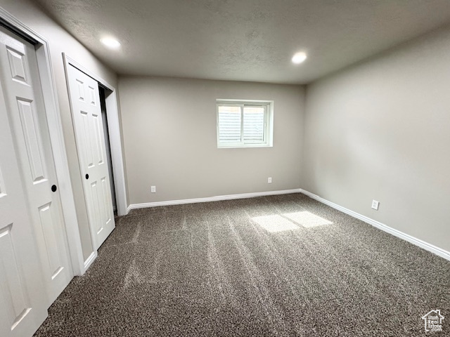 Unfurnished bedroom featuring dark colored carpet, baseboards, and recessed lighting