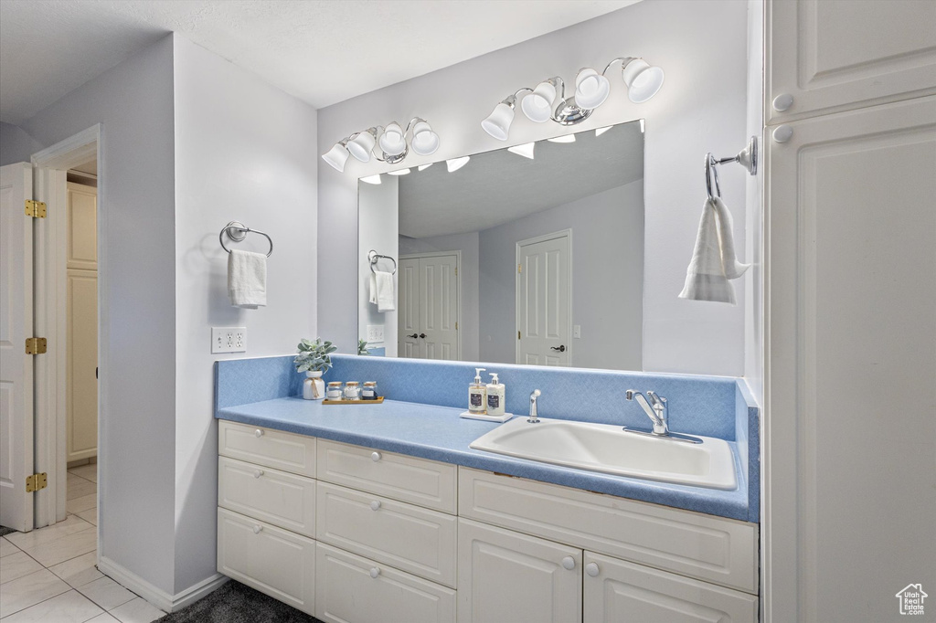 Bathroom with vanity, tile patterned flooring, and baseboards