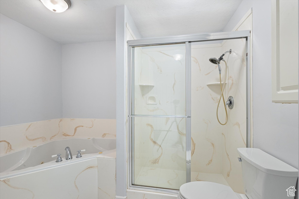 Full bath with toilet, a bath, and a marble finish shower