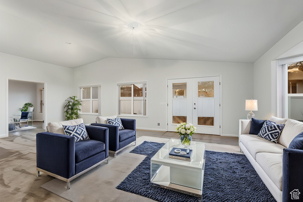 Living area featuring vaulted ceiling, french doors, and baseboards