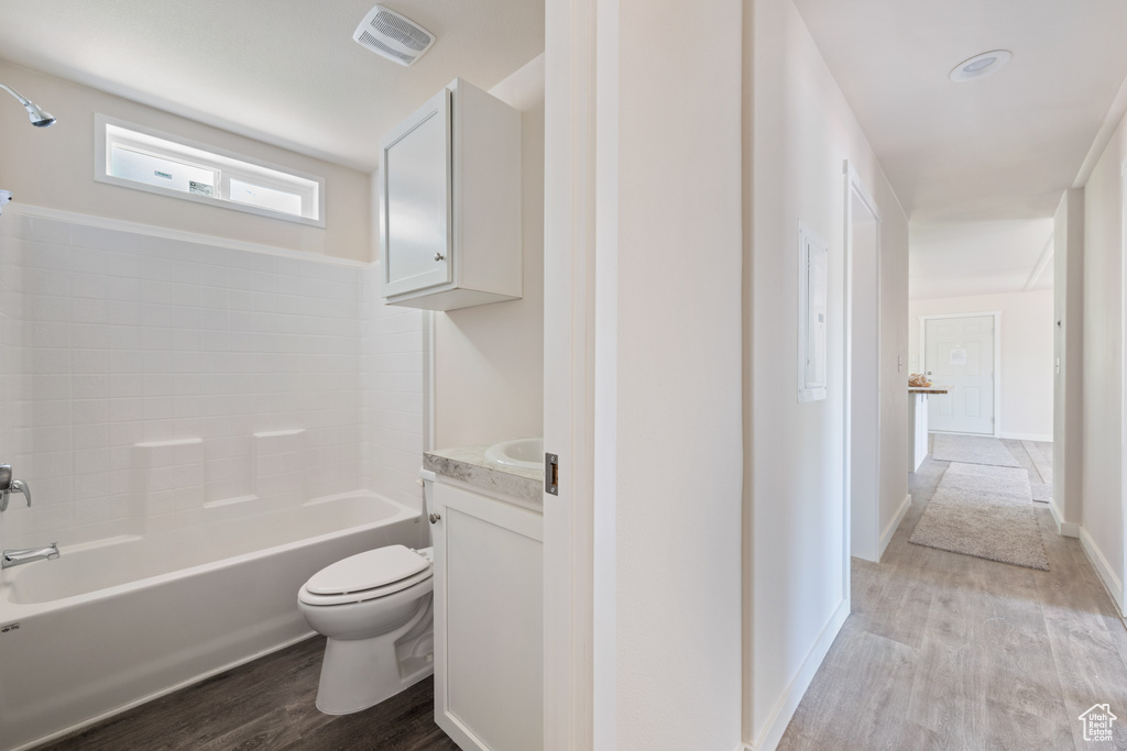Bathroom with toilet, wood finished floors, vanity, and baseboards