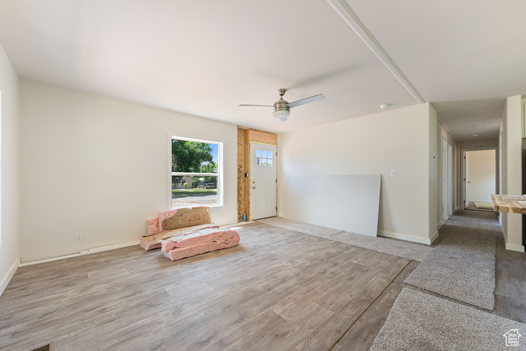 Unfurnished room with a ceiling fan, wood finished floors, and baseboards