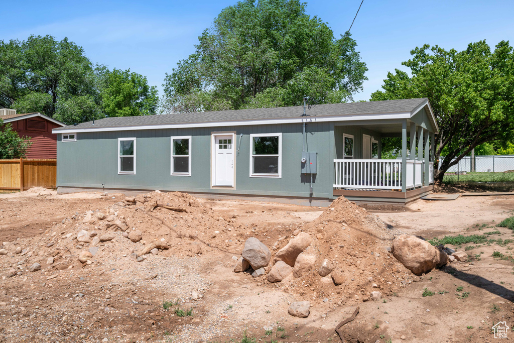 View of front of house with a shingled roof and a porch