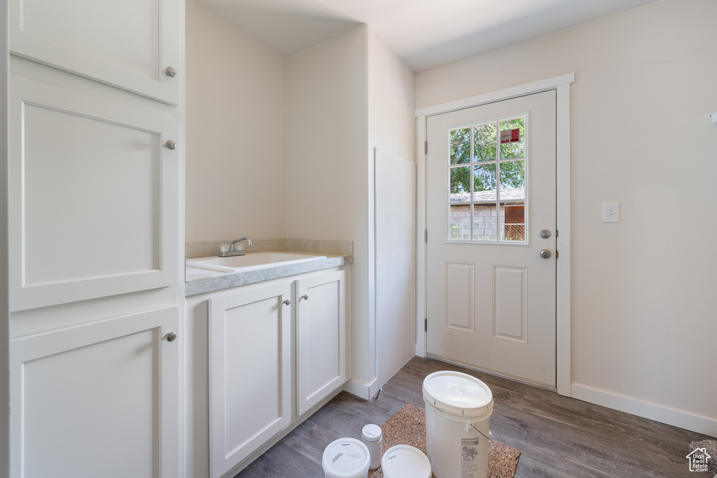 Entryway with wood finished floors, a sink, and baseboards
