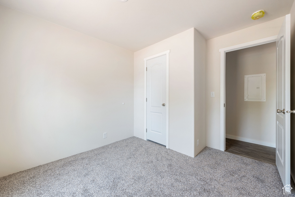 Unfurnished bedroom with carpet flooring and electric panel