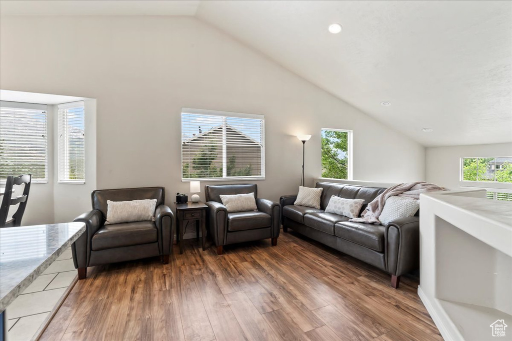 Living area featuring wood finished floors, recessed lighting, and high vaulted ceiling