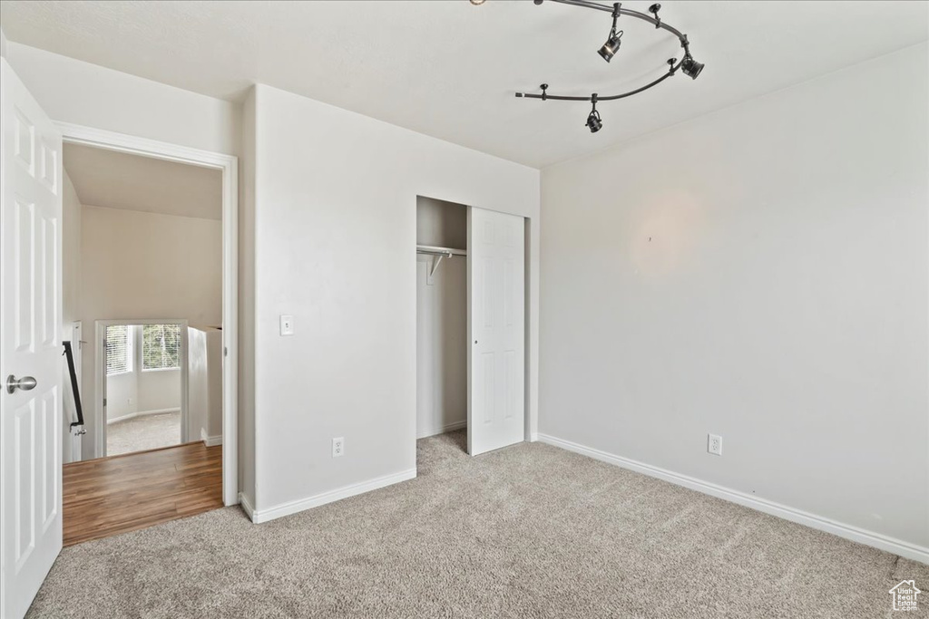 Unfurnished bedroom featuring carpet, a closet, and baseboards