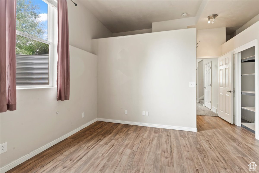 Unfurnished room with light wood finished floors and baseboards