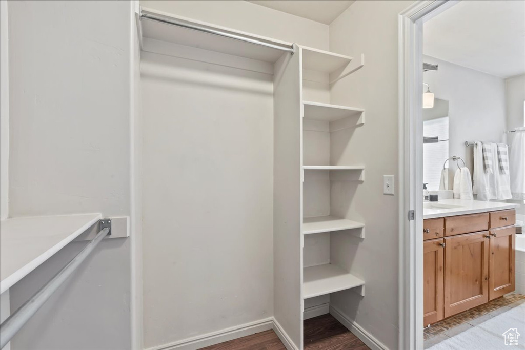Walk in closet with light wood-style floors