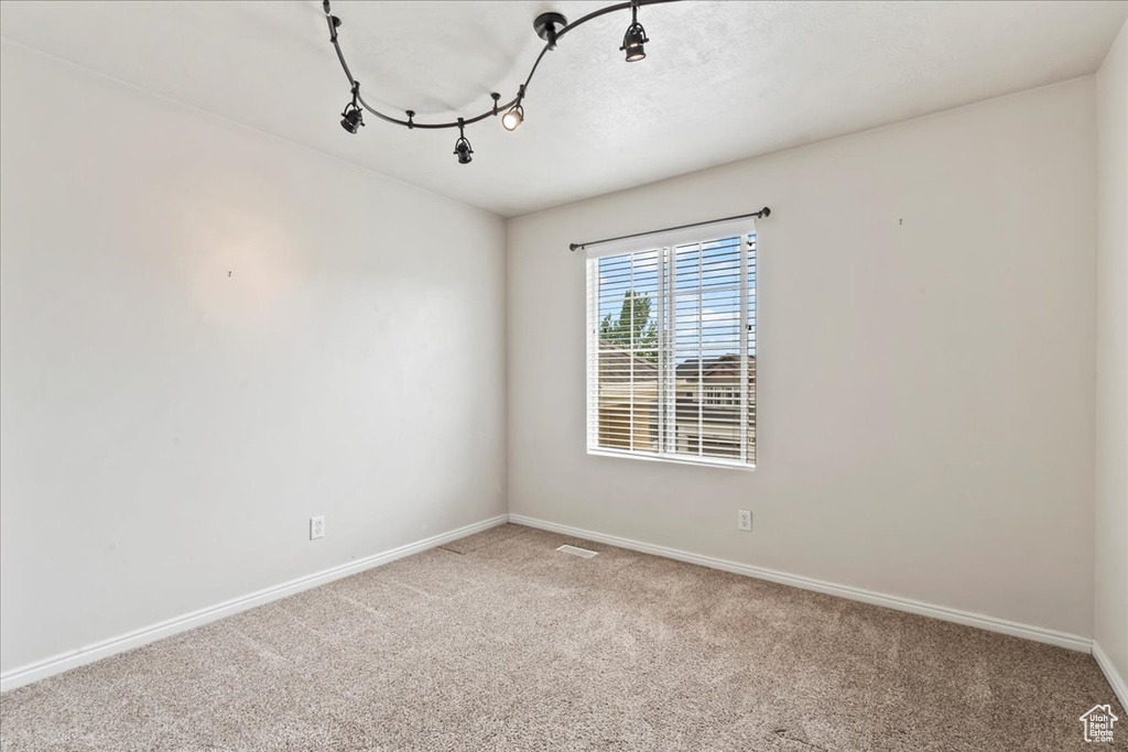 Spare room featuring carpet and baseboards