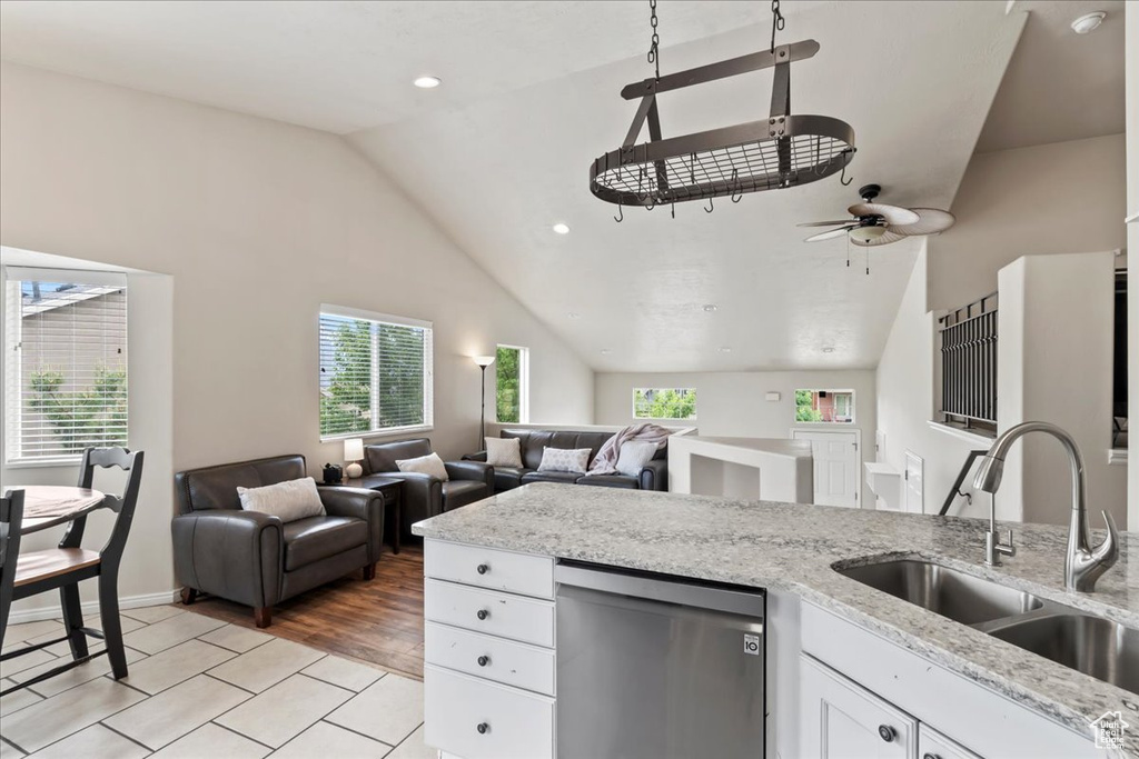 Kitchen with dishwasher, a sink, vaulted ceiling, plenty of natural light, and a ceiling fan