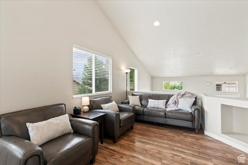 Living area with wood finished floors and lofted ceiling