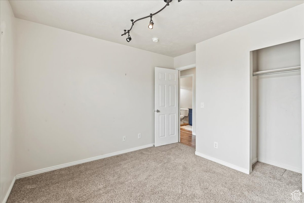 Unfurnished bedroom with carpet flooring, baseboards, and a closet