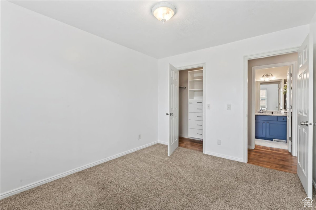 Unfurnished bedroom with carpet floors, baseboards, a spacious closet, and a closet