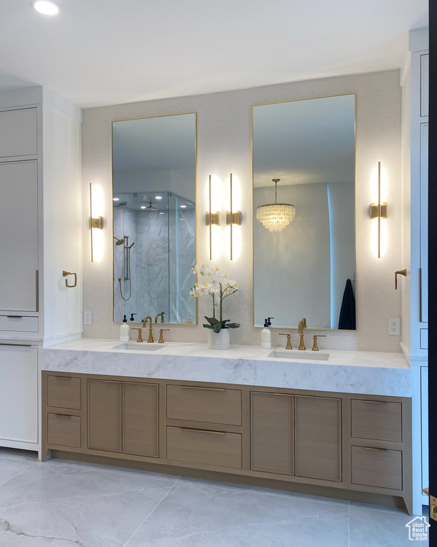 Bathroom with a marble finish shower and double vanity