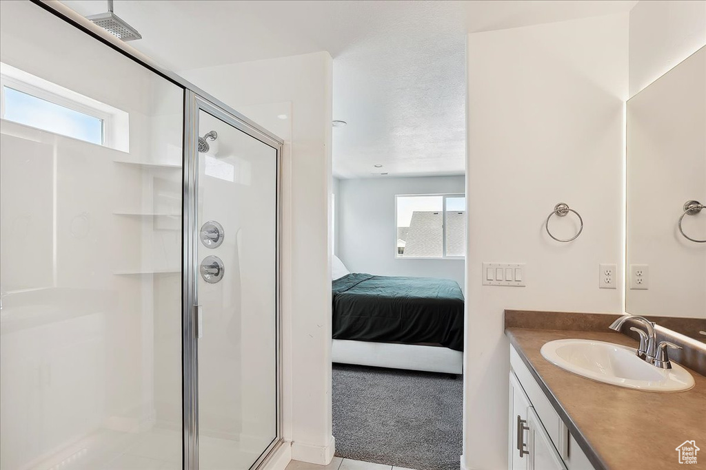 Full bathroom featuring a stall shower, ensuite bath, and vanity