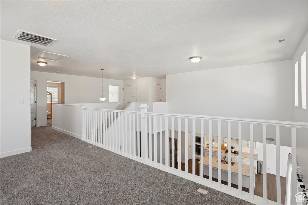 Hallway featuring carpet floors and baseboards