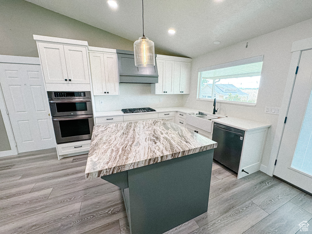 Kitchen with dishwashing machine, a sink, lofted ceiling, double oven, and black gas stovetop