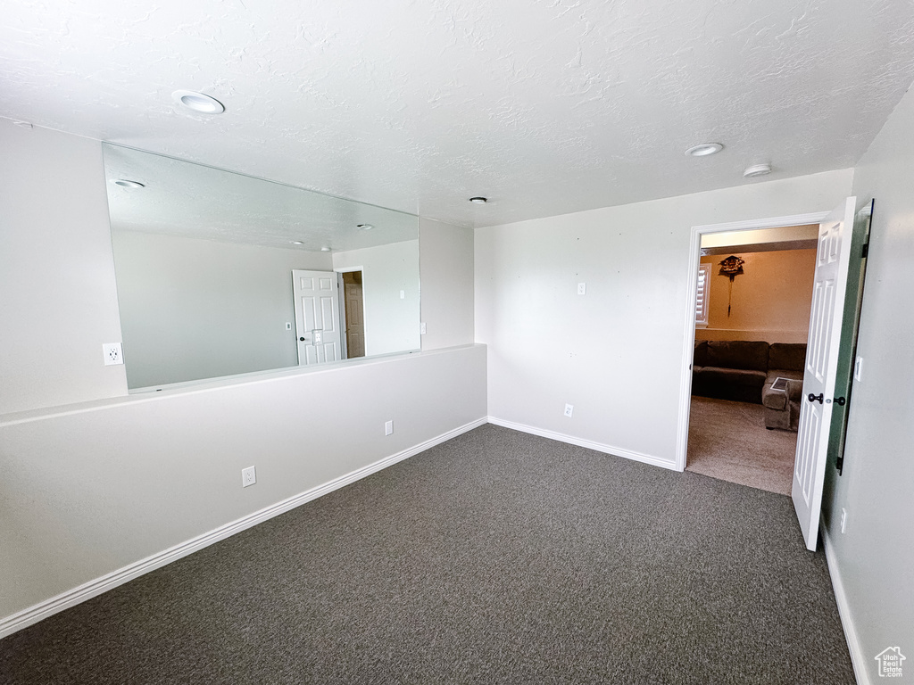 Unfurnished room featuring carpet, baseboards, a textured ceiling, recessed lighting, and a smoke detector