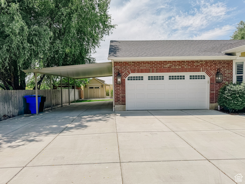View of front facade with driveway, brick siding, and a garage
