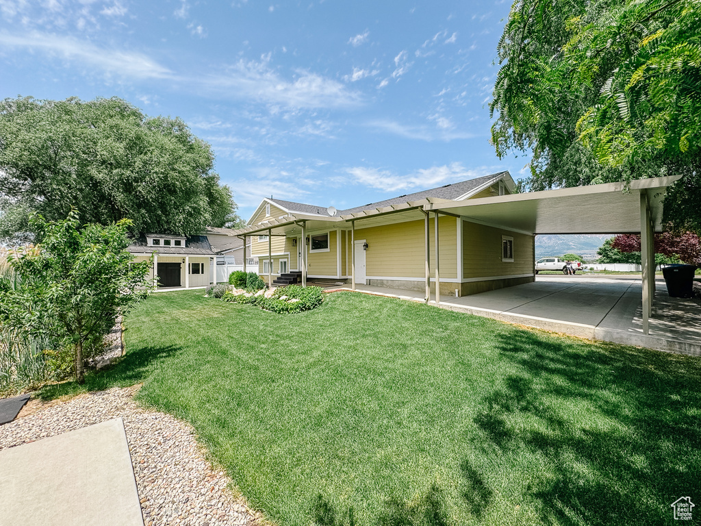 View of front of house with a front yard, a porch, and an attached carport