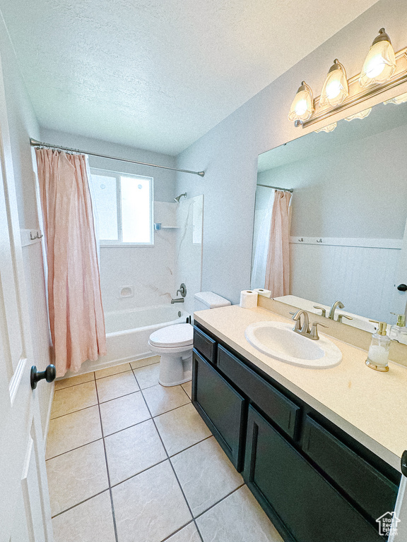 Full bath with vanity, shower / tub combo, tile patterned floors, toilet, and a textured ceiling