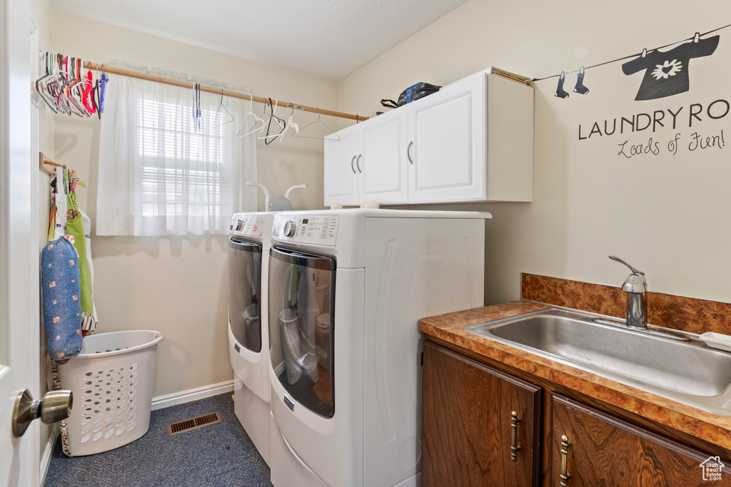 Washroom with washing machine and clothes dryer, cabinet space, and baseboards