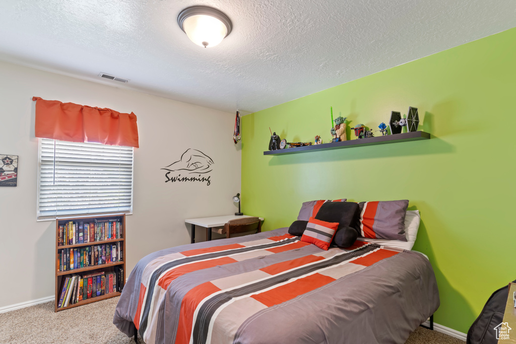 Bedroom featuring carpet flooring, a textured ceiling, and baseboards