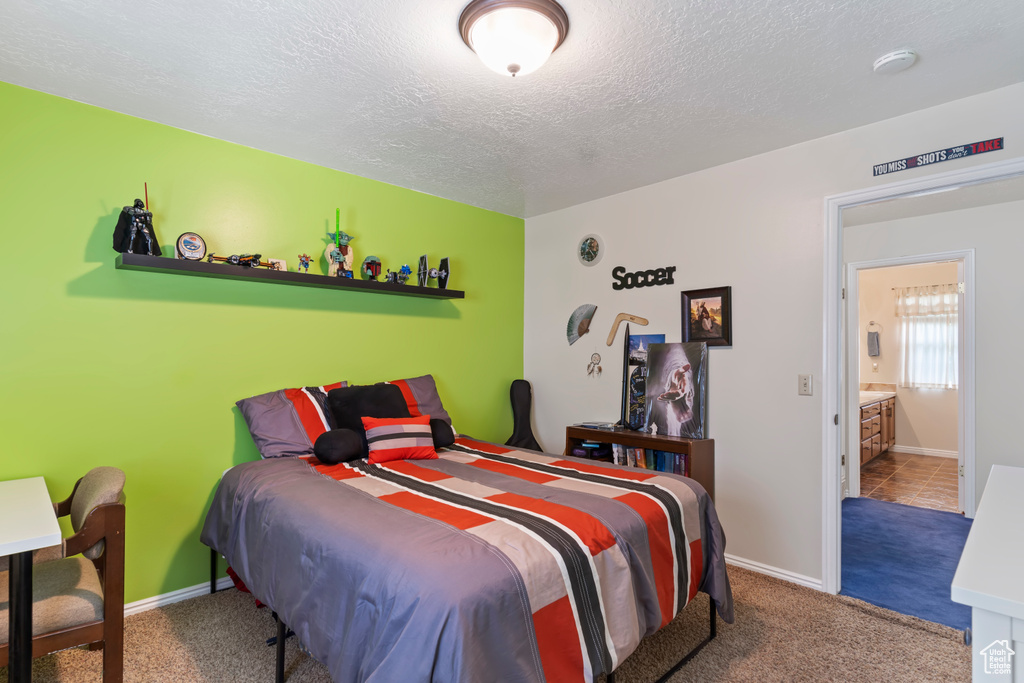 Carpeted bedroom featuring a textured ceiling and baseboards