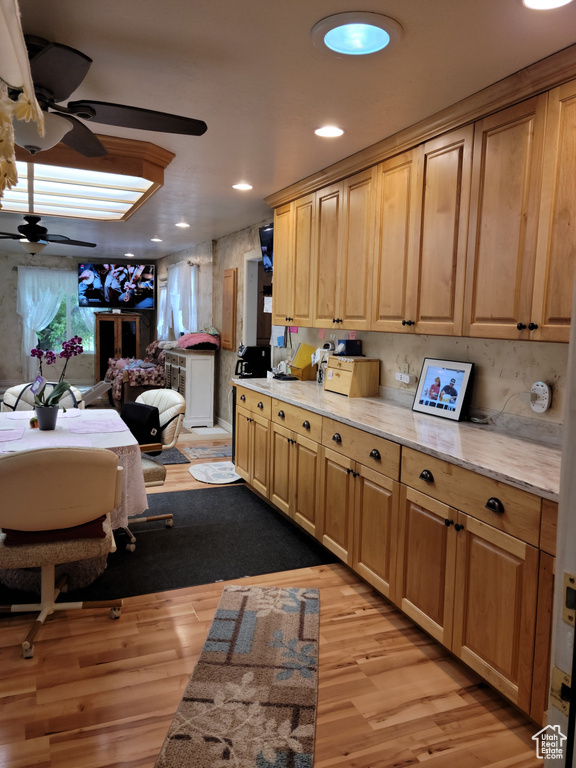 Kitchen featuring a ceiling fan, light wood-style flooring, open floor plan, recessed lighting, and light stone countertops