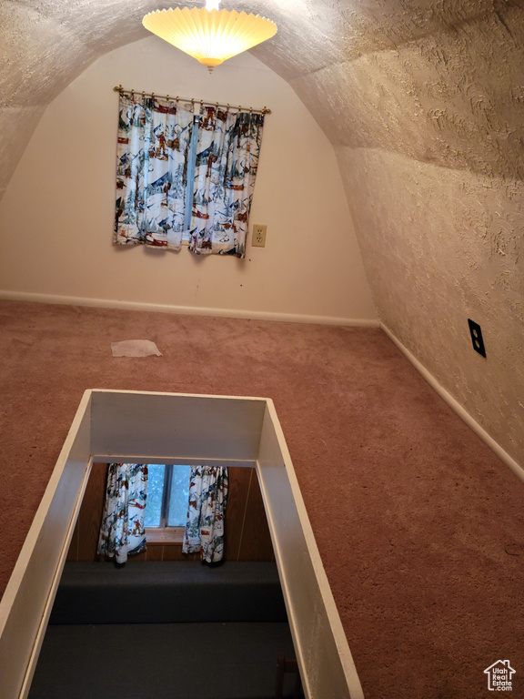 Bonus room featuring lofted ceiling, carpet floors, and baseboards