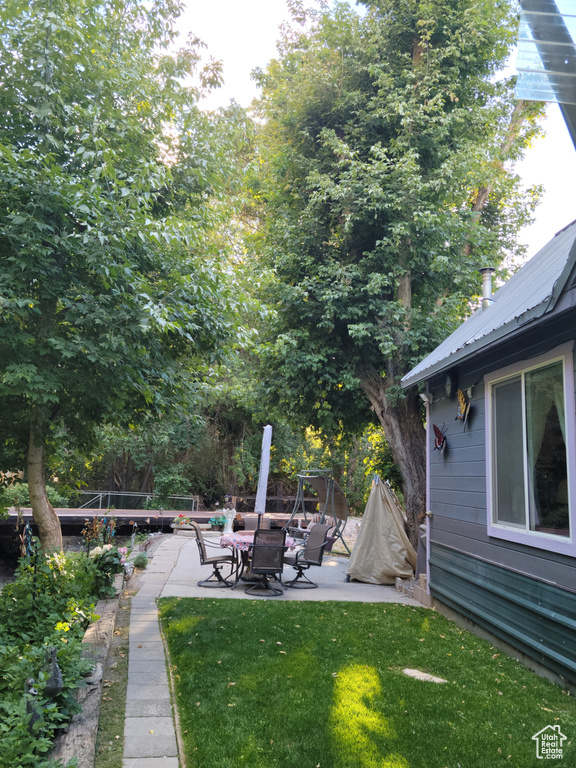 View of grassy yard with a patio