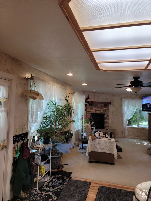 Living room with ceiling fan, a fireplace, and wood finished floors