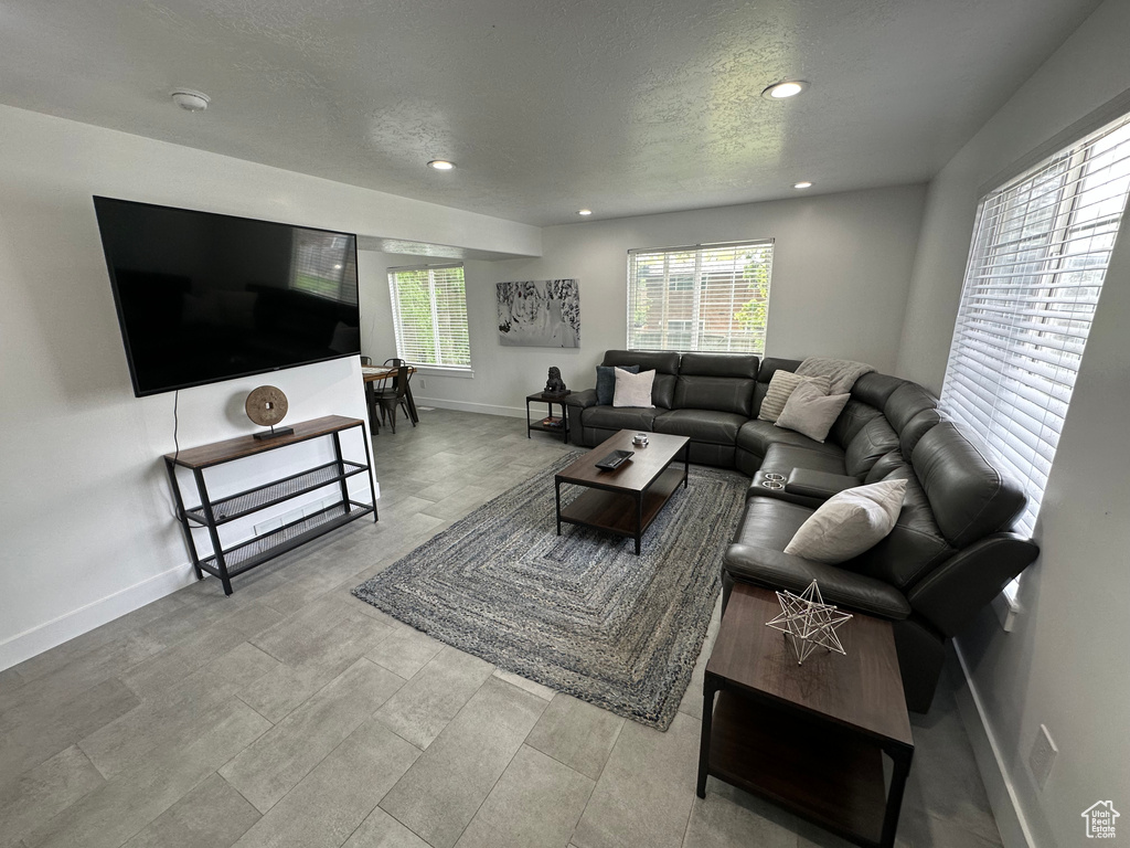 Living area with recessed lighting, baseboards, and a textured ceiling