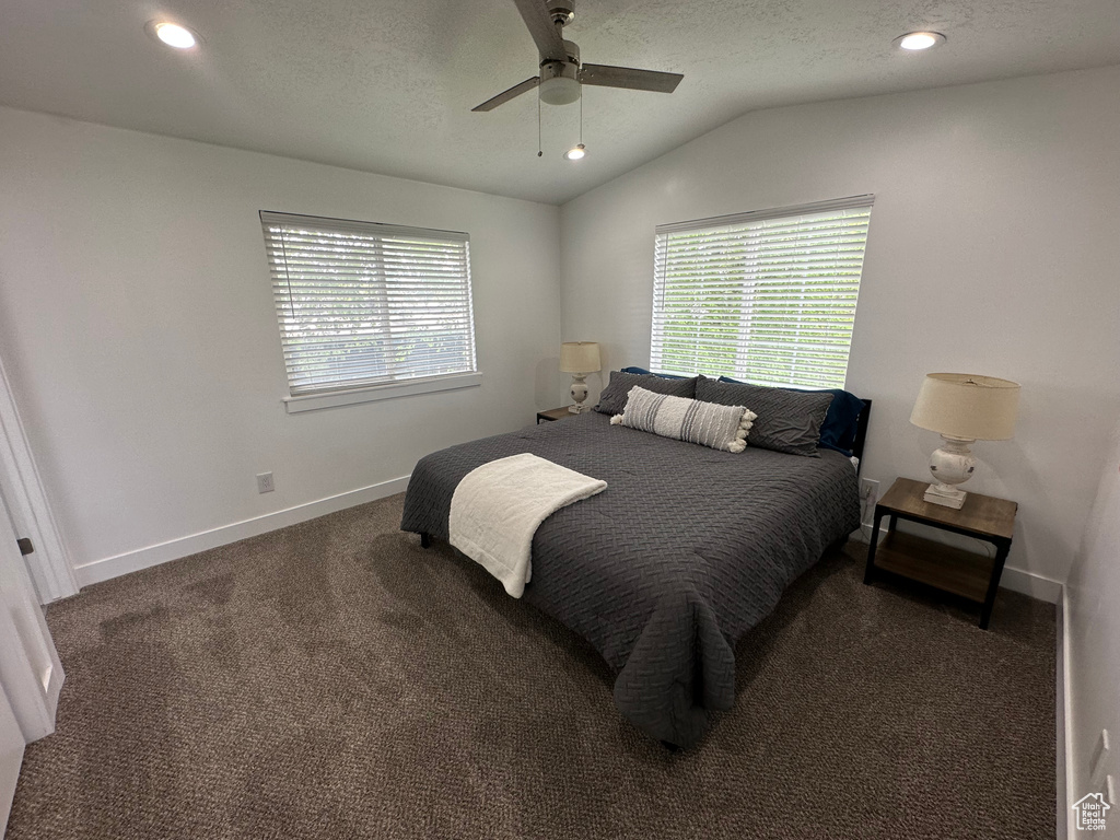 Carpeted bedroom with vaulted ceiling, multiple windows, baseboards, recessed lighting, and a ceiling fan