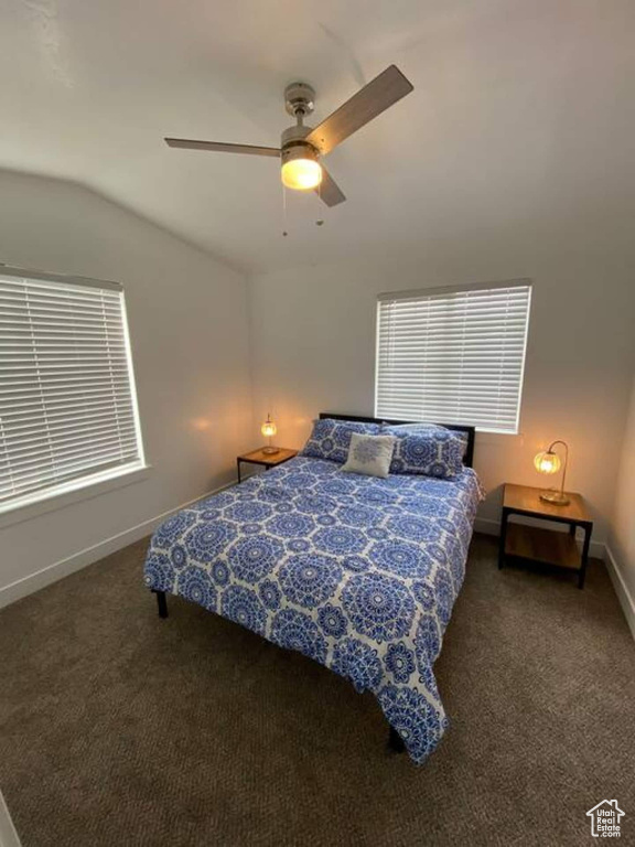 Bedroom featuring vaulted ceiling, carpet, baseboards, and a ceiling fan