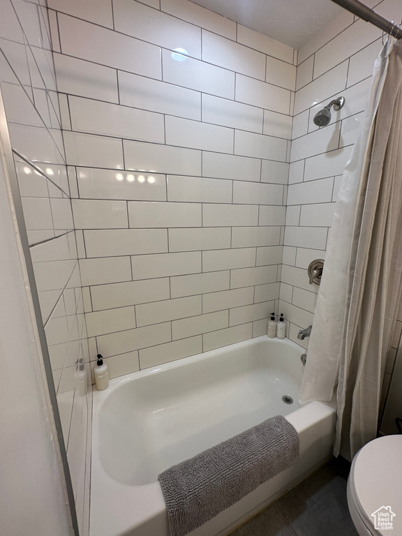 Bathroom with shower / tub combo with curtain and toilet