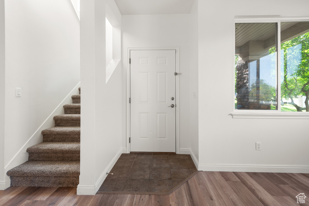 Foyer with stairway, wood finished floors, and baseboards