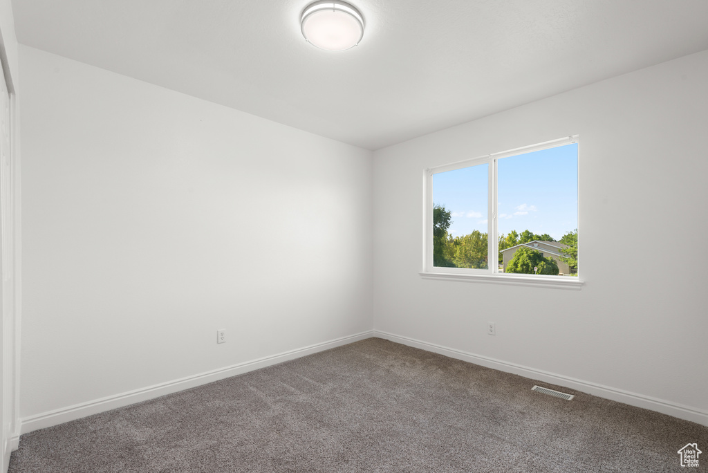 Carpeted empty room featuring baseboards