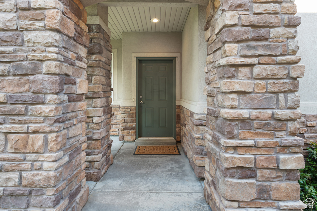 Entrance to property featuring stone siding