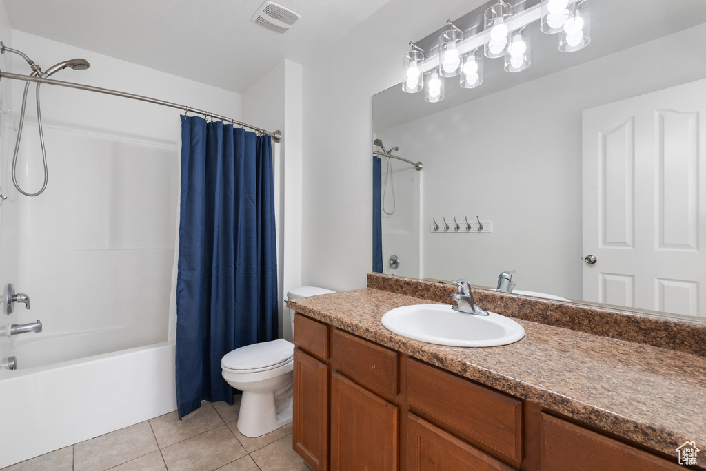Full bath with toilet, vanity, shower / bath combo, and tile patterned floors