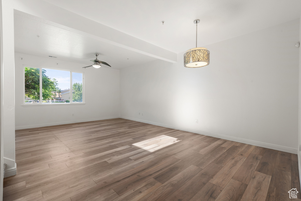 Spare room with wood finished floors, baseboards, and ceiling fan