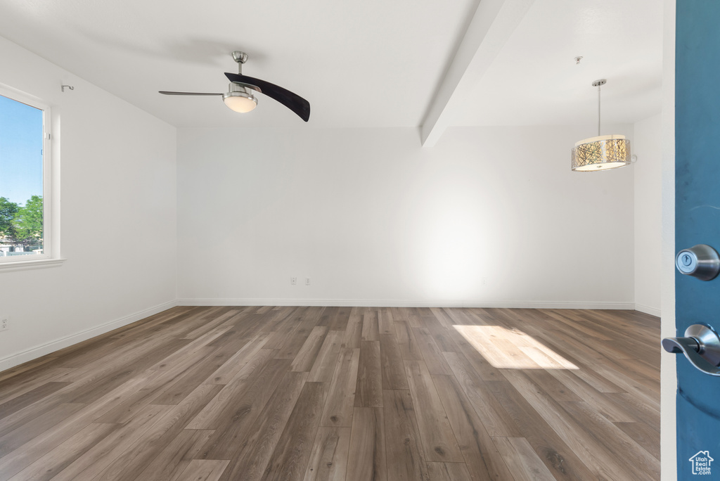 Unfurnished room with wood finished floors, a ceiling fan, and baseboards