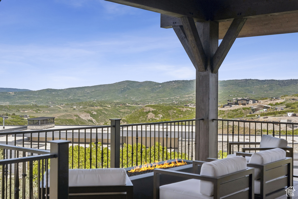 Balcony featuring a mountain view and an outdoor living space with a fire pit