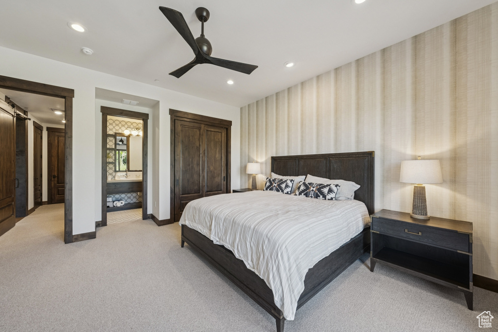 Bedroom featuring baseboards, wallpapered walls, light carpet, a barn door, and recessed lighting