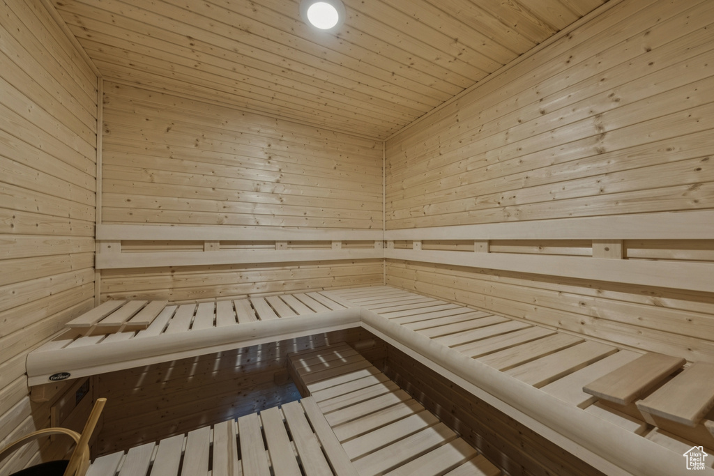 Relaxing sauna featuring wooden walls and wooden ceiling