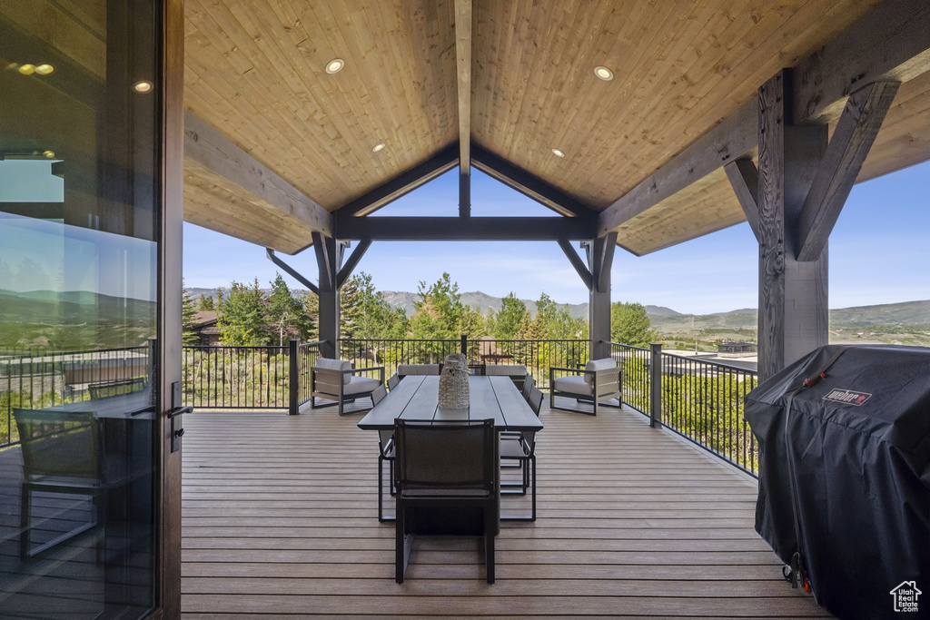 Wooden terrace with a mountain view, a grill, and outdoor dining area
