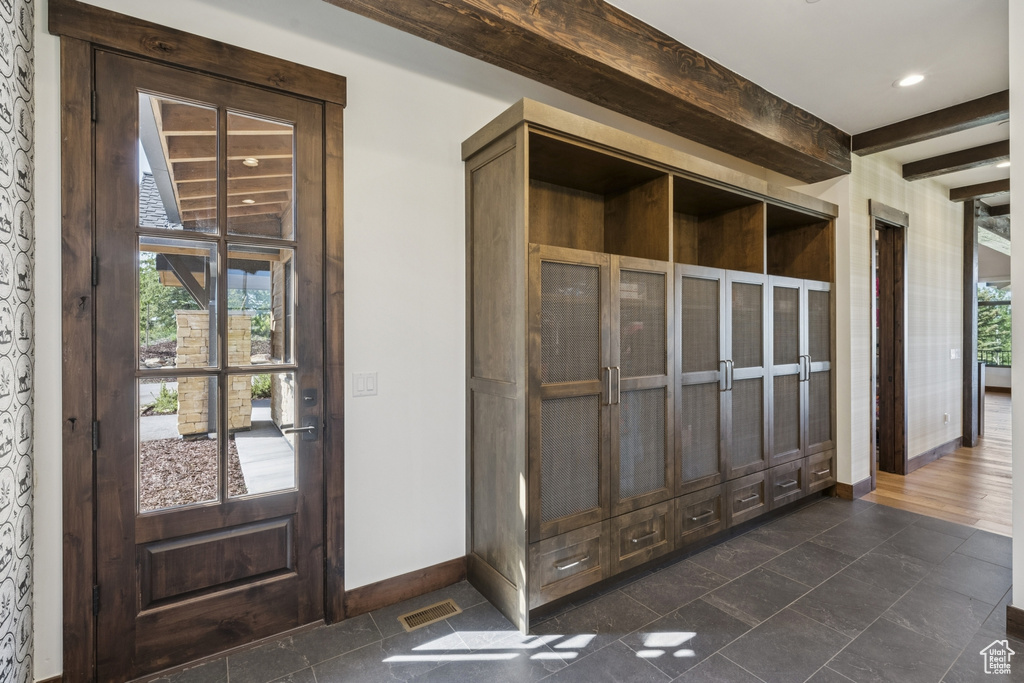 Detailed view of baseboards, beam ceiling, and recessed lighting